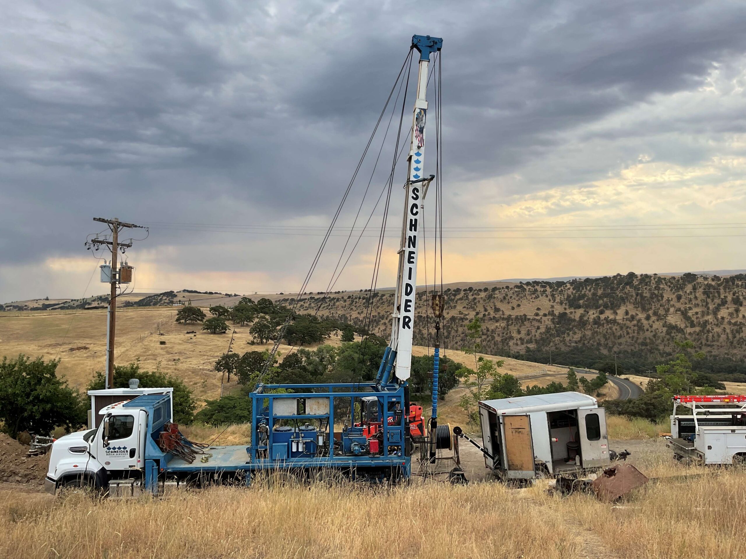 Schneider Water Services Well Rehabilitation project showing a truck with the Schneider logo on a hill with the sun setting