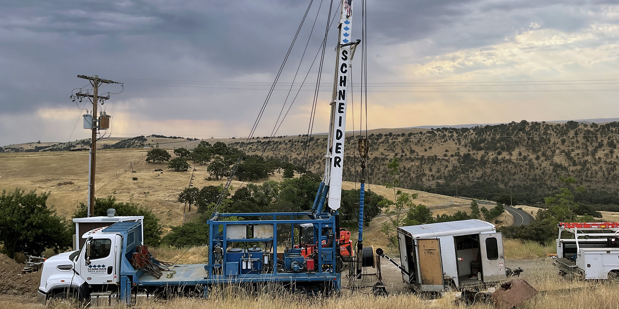 Schneider Water Services Well Rehabilitation project showing a truck with the Schneider logo on a hill with the sun setting